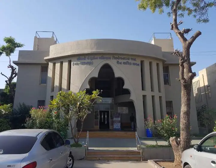 Arched entrance of a dharamshala building with garden