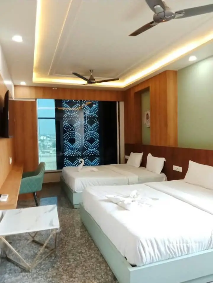 Room with two double beds, wood panelling and cove lighting