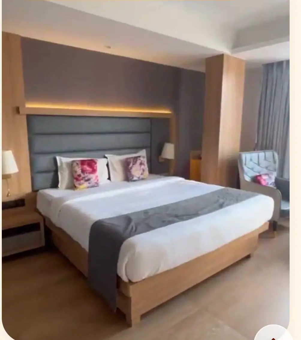 Room with king-size bed, upholstered headboard and armchair