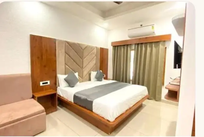 Double room with wooden headboard, sofa and air conditioner