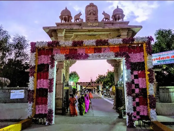 Flower-decorated Prem Dwar gate at the Shankheshwar temple complex at dusk